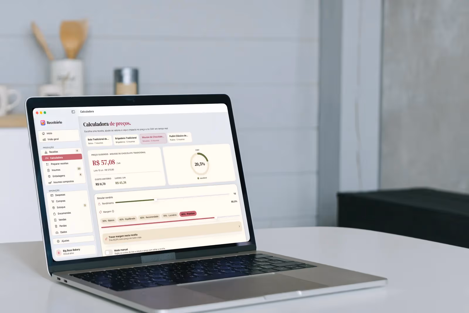 MacBook aberto numa bancada de cozinha com a Calculadora de preços do Receitório, mostrando preço sugerido, custo unitário, lucro e CMV