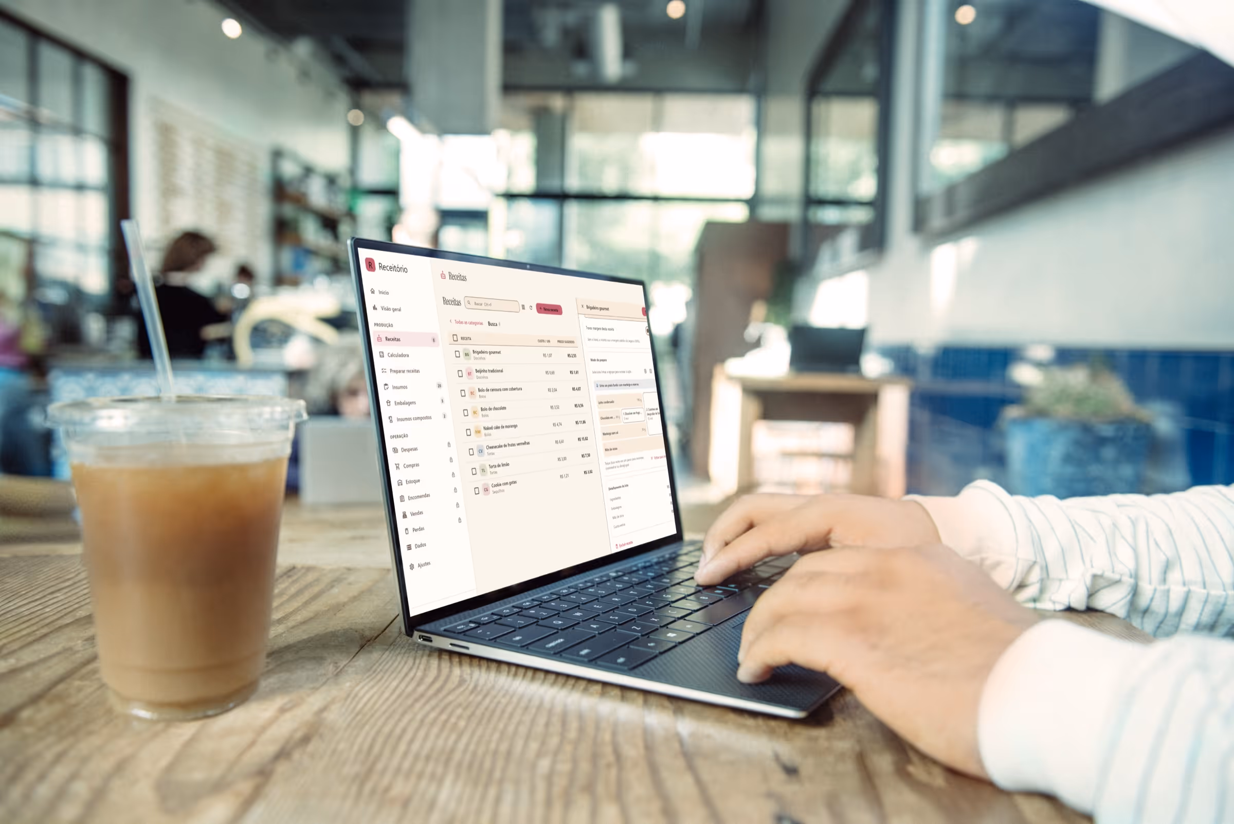 Notebook com o Receitório para Windows aberto na tela de receitas, sobre uma bancada com uma xícara de café